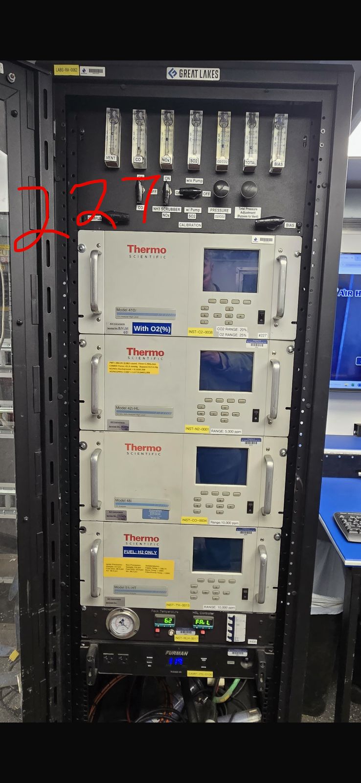 A full CEMS rack of stacked Thermo analyzers, hand-numbered 227 in red marker