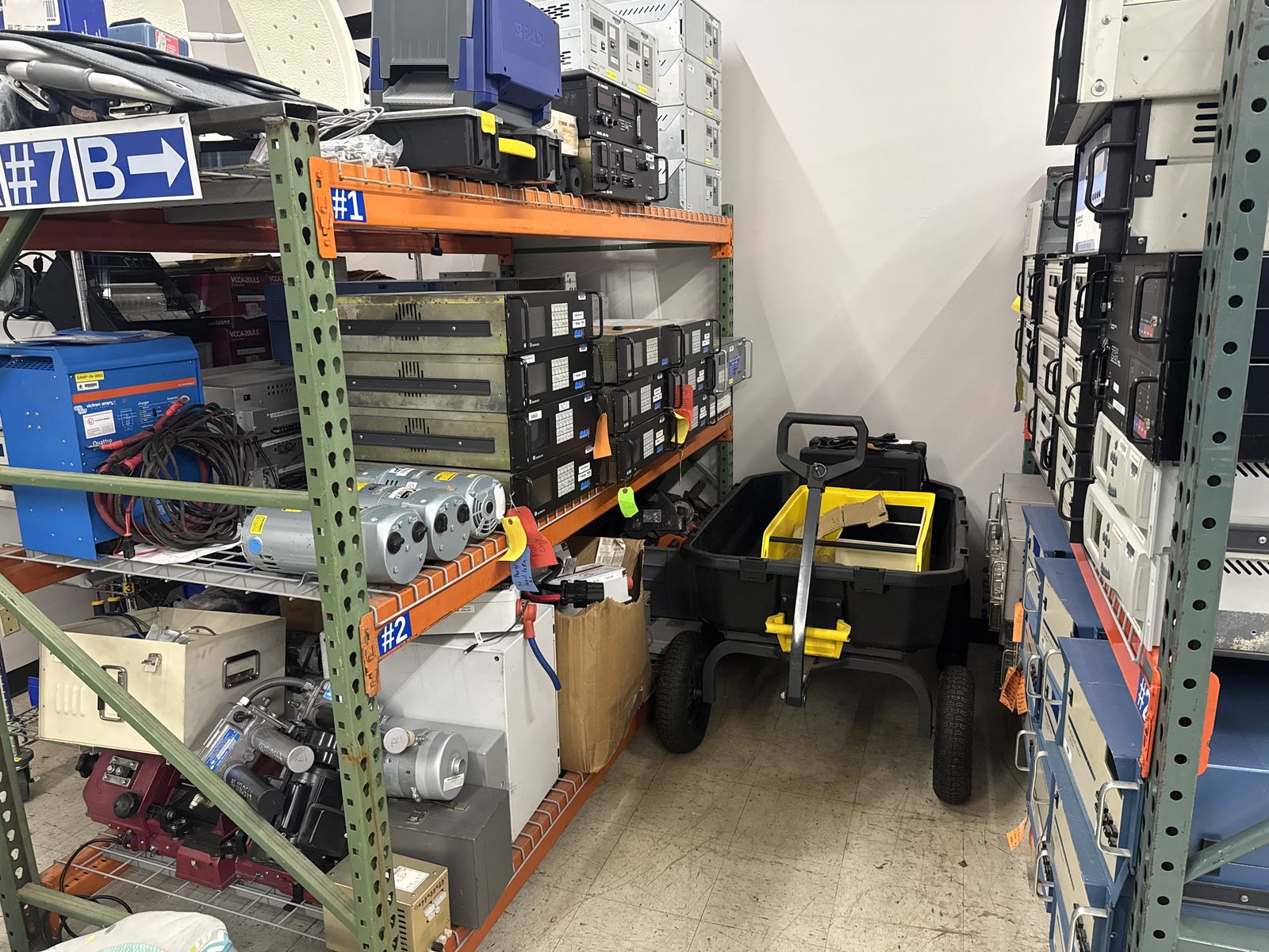 Pallet racking with instruments alongside gas cylinders and a pallet jack